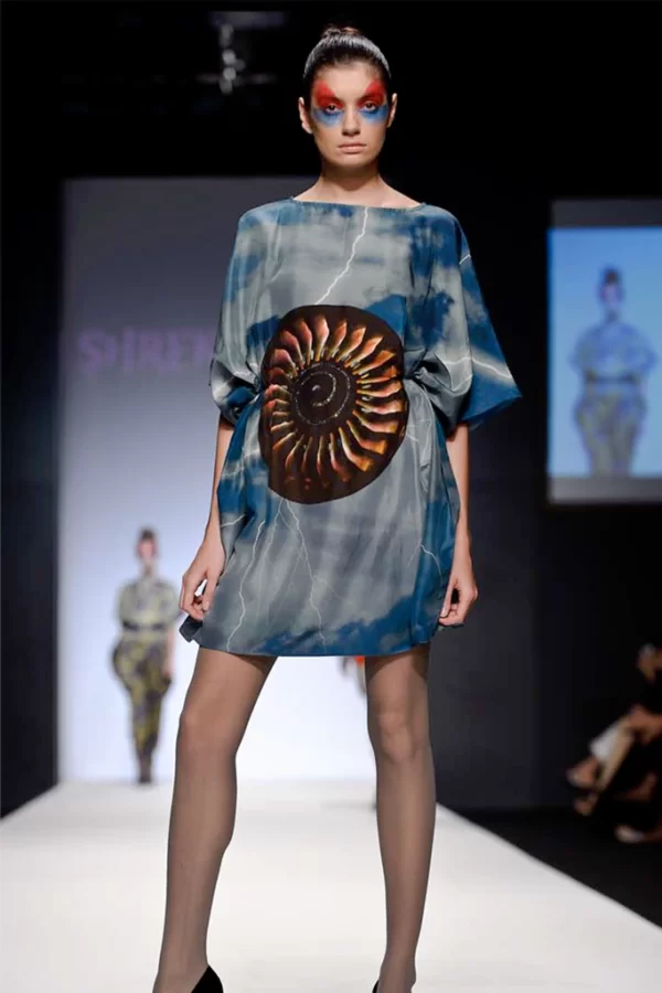 A printed short dress shown in Dubai Fashion Week . The print is Industrial art of Airline Turbine.