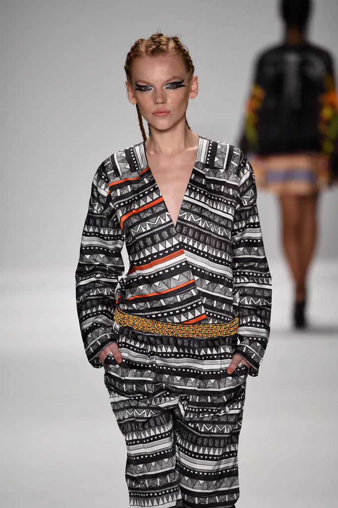 طبعات حيوانات وتصاميم قبلية حصرية: إبداع في أسبوع الموضة بنيويورك – ربيع/صيف 2015 14 Silk jumpsuit with glass beaded hand embroidery at waist, black and white geometric tribal prints, worn by model on runway at Mercedes-Benz New York Fashion Week