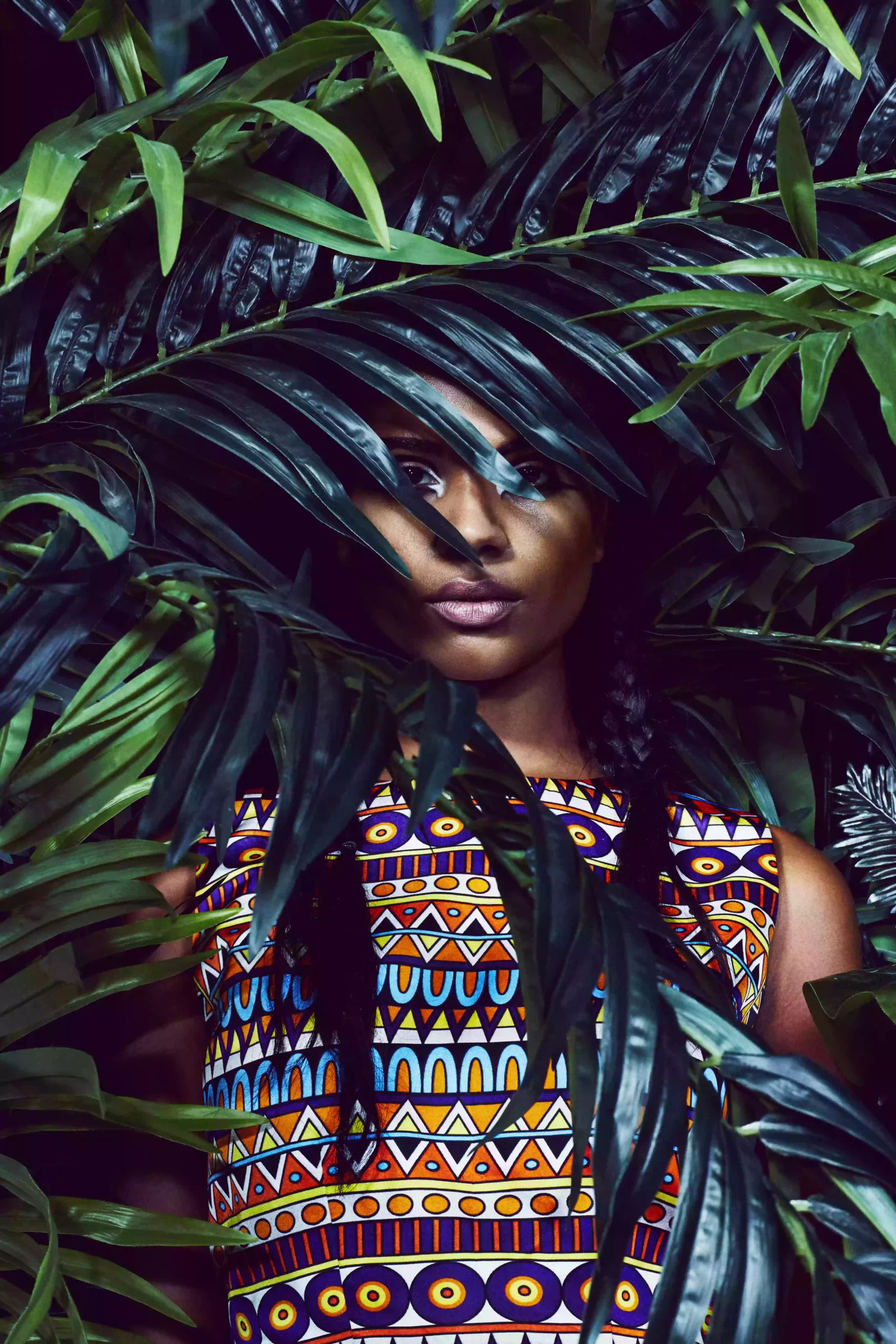 SHREKAHNTH — HOME 2026 5 Portrait of a model wearing a silk dress with tribal design prints, shot against a palm tree backdrop.