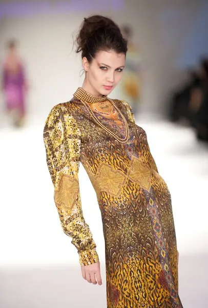 SHREKAHNTH — HOME 2026 3 Model wearing a full-sleeve satin thobe dress with a snake print and a pearl-embellished collar in omani fashion.