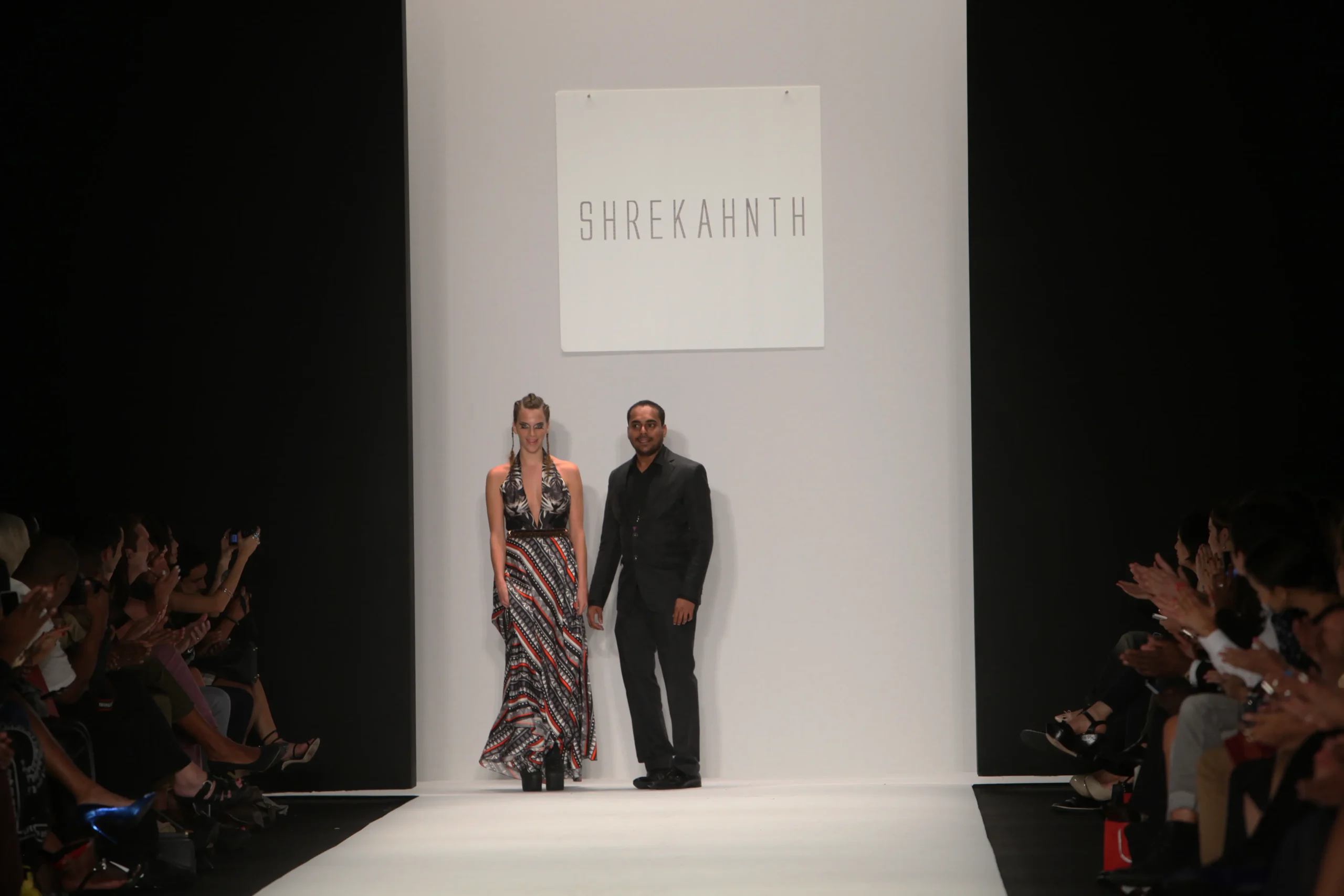 SHREKAHNTH — HOME 2026 1 Runway moment with the audience clapping as the designers arrive to celebrate the collection.