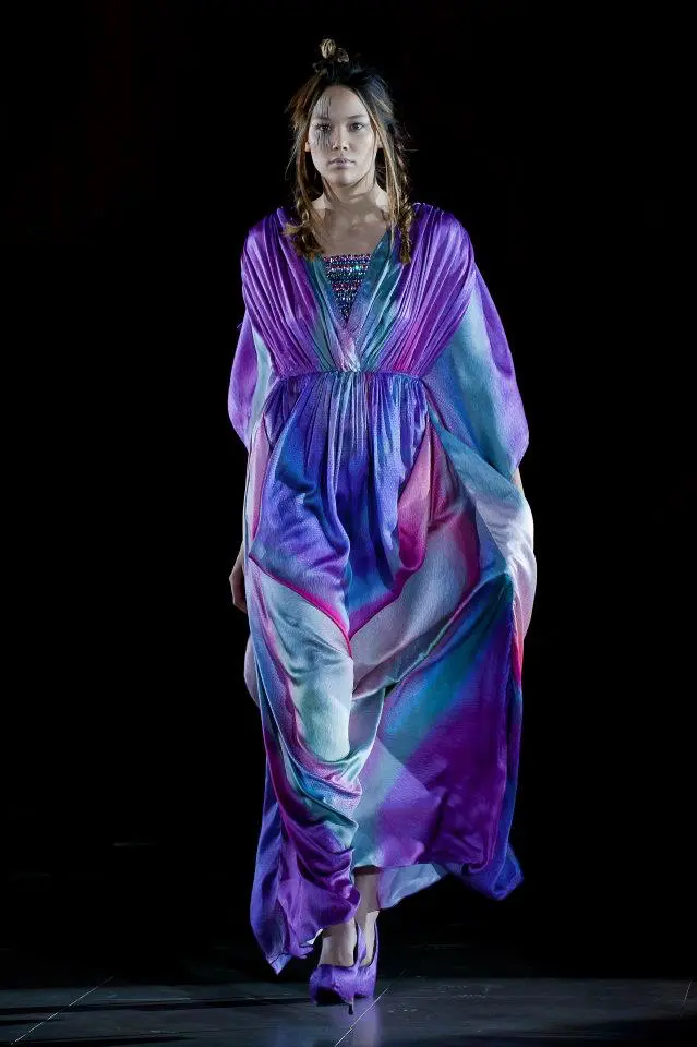 SHREKAHNTH — HOME 2026 2 Model wearing a silk satin kaftan with 3/4 sleeves, ombré in purple and blue, featuring shoulder and waist gathers and Swarovski embroidery on the deep neckline.